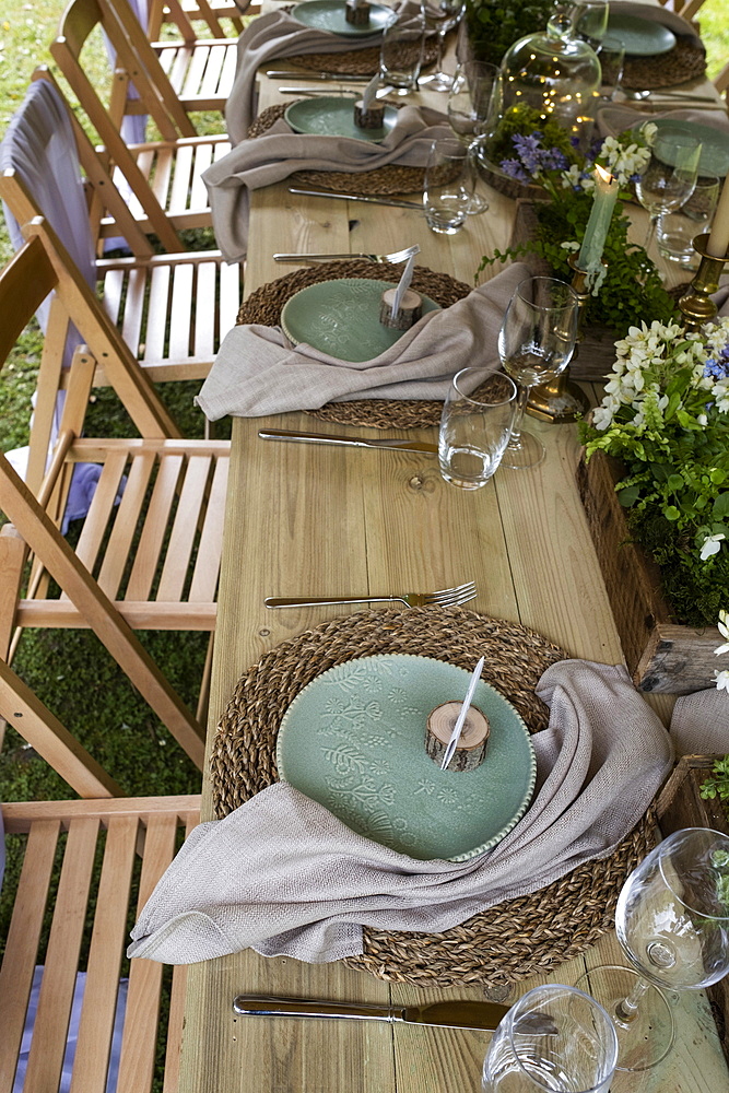 High angle close up of rustic place settings for a woodland naming ceremony.