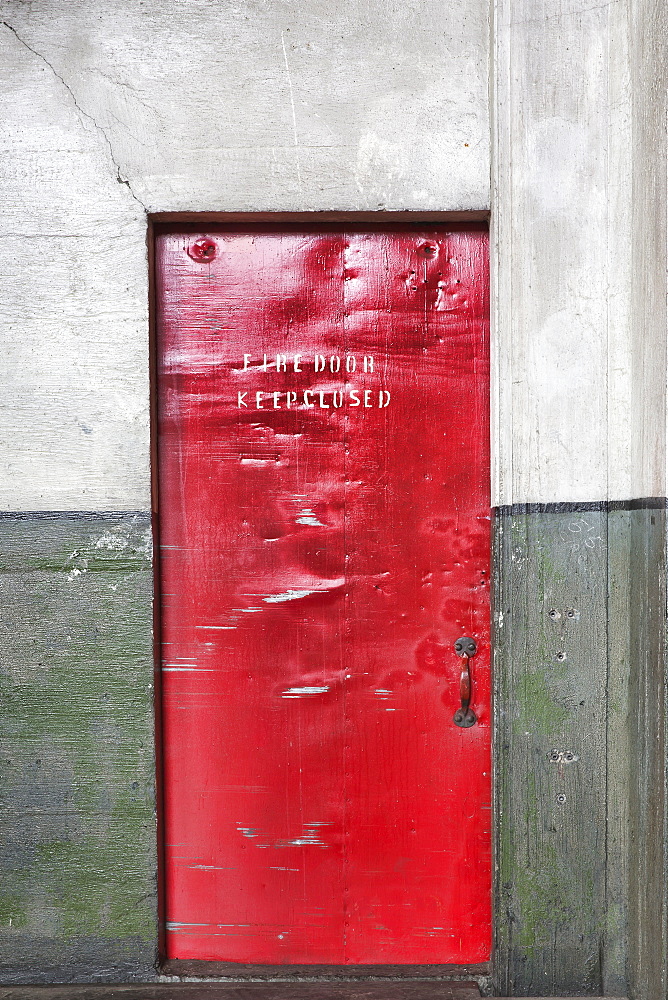 A red barrier fire door in a museum, notice Fire Door Keep Closed, dents and marks on the metal, Seattle, Washington, United States