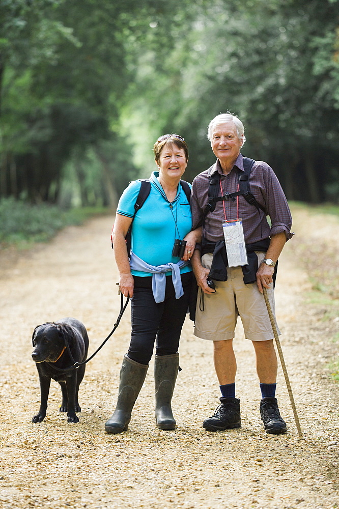 A mature couple hiking with their dog, England