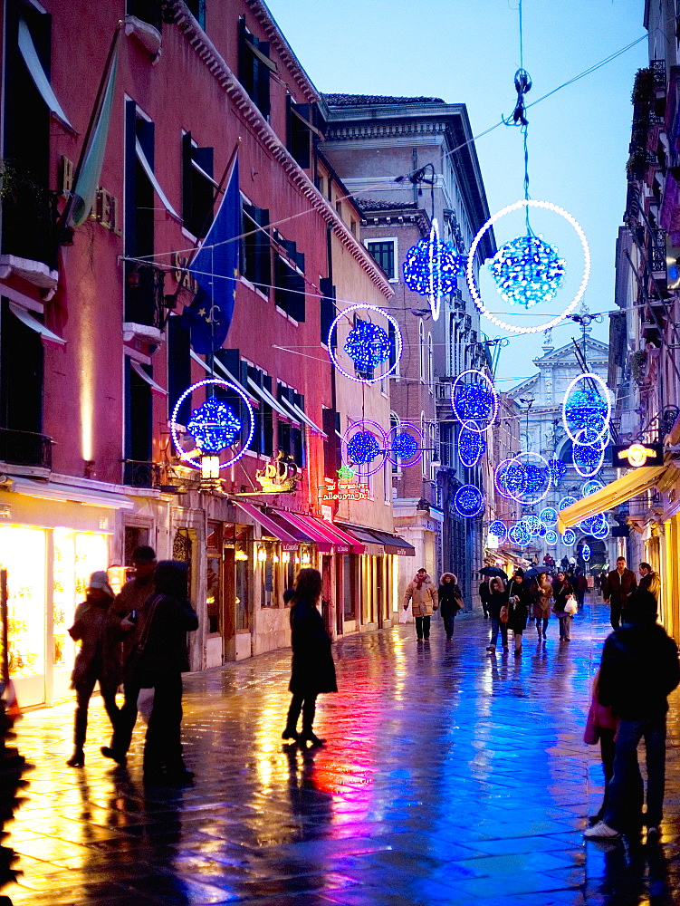 People walking in a narrow street at night, Street lights and decorations, Venice, Italy