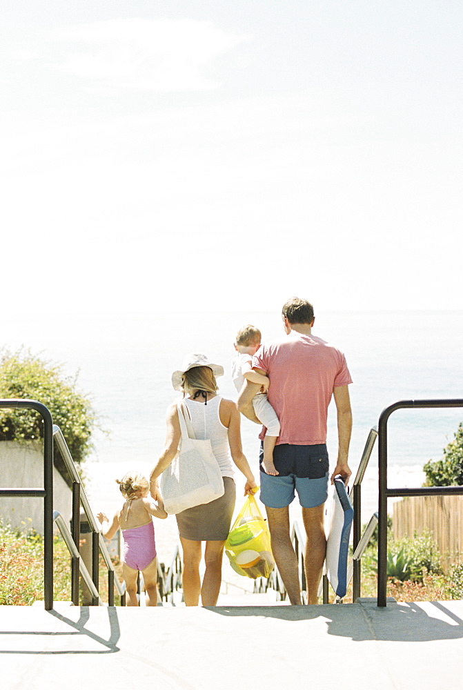 Family on a day out at a sandy beach by the ocean.