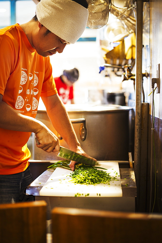 The ramen noodle shop. A chef chopping vegetables, Japan