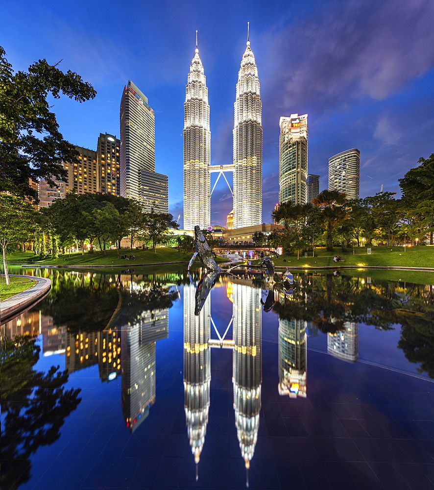 Illuminated Petronas Towers building in Kuala Lumpur, Malaysia at dusk, Reflection in lake, Kuala Lumpur, Malaysia