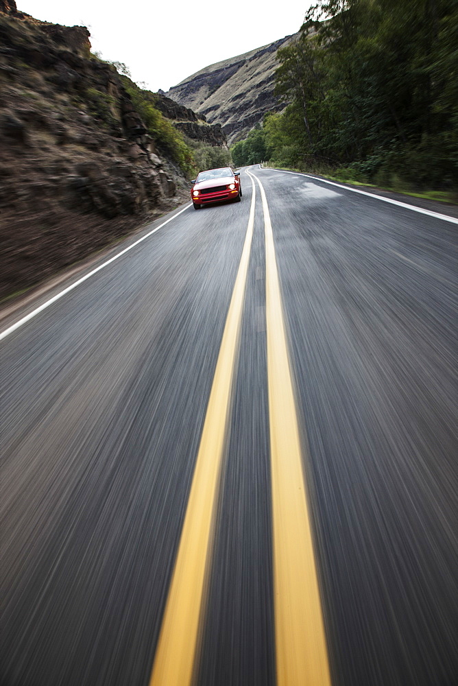 A blurred road and a car traveling along a highway in eastern Washington State, United States of America