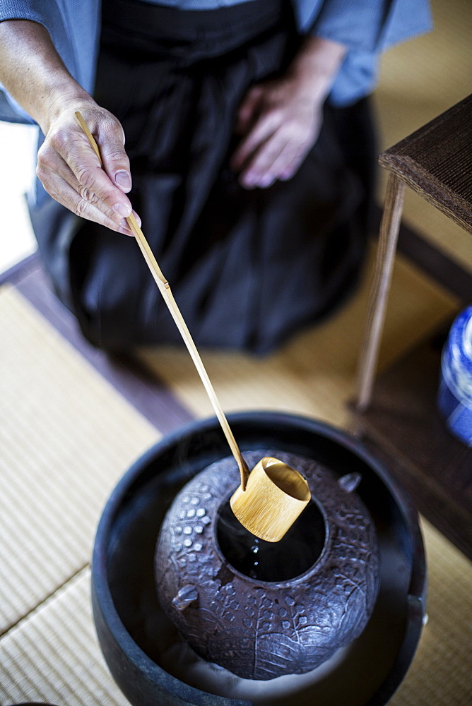 High angle close up of traditional Japanese Tea Ceremony, man using a Hishaku, a bamboo ladle, to pour hot water, Kyushu, Japan