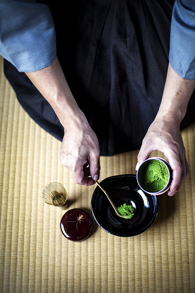 High angle close up of traditional Japanese Tea Ceremony, man spooning green Matcha tea powder into bowl, Kyushu, Japan