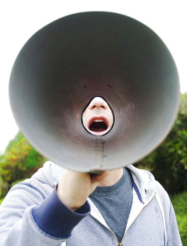 A man using a megaphone in the open air. 