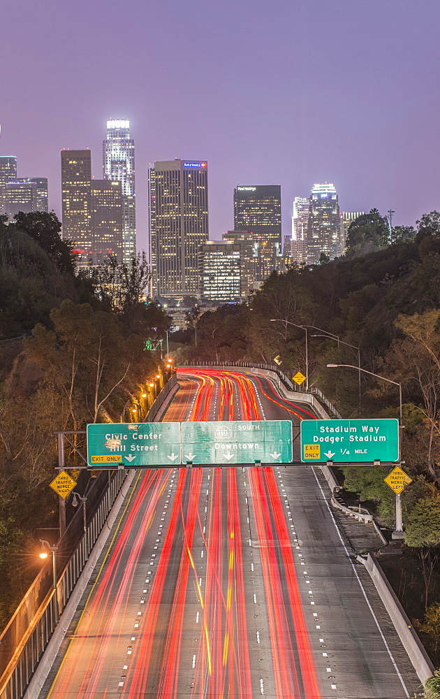 Los Angeles city skyline over busy highway illuminated at night, California, United States