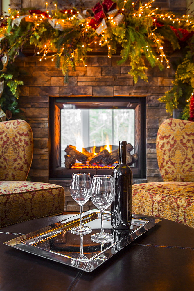 Glasses with wine bottle in living room at Christmas