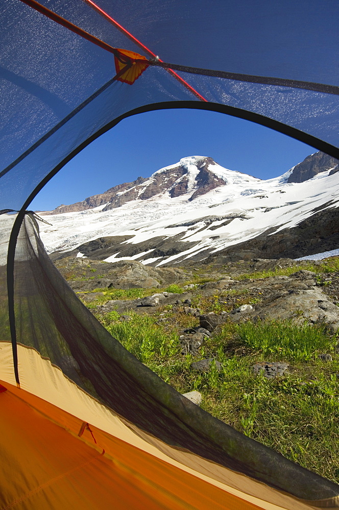 View from tent under snowy mountainside, North Cascades, Washington, USA