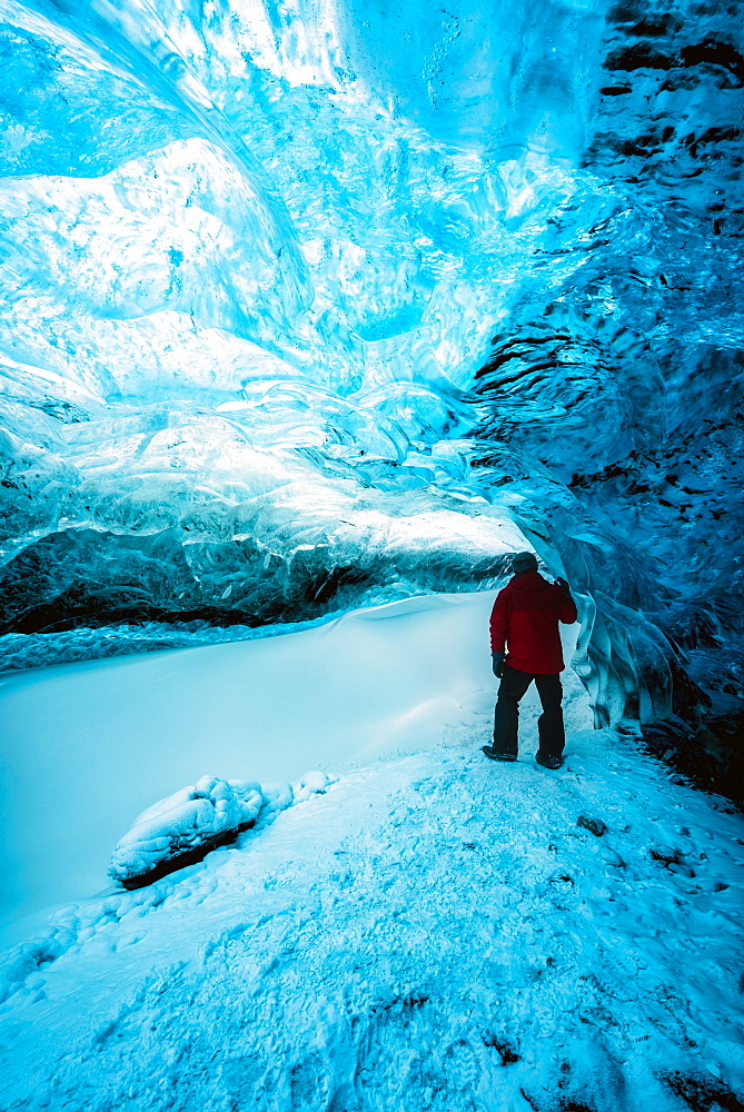 Hiker walking in ice cave, Jokulsarlon, Iceland