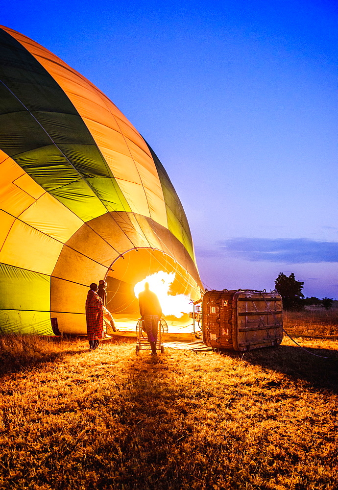 Hot air balloon inflating in rural field, Kenya, Africa