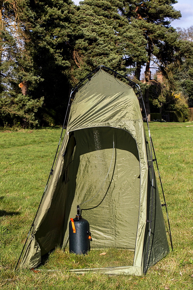 Green shower tent pitched on a meadow, Oxfordshire, England