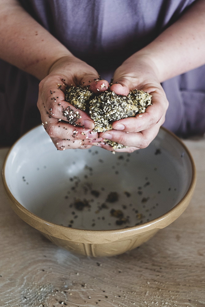 High angle close up of person kneading dough over mixing bowl, England