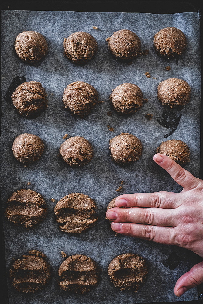 High angle close up of person putting chocolate cookie dough on a baking tray, England