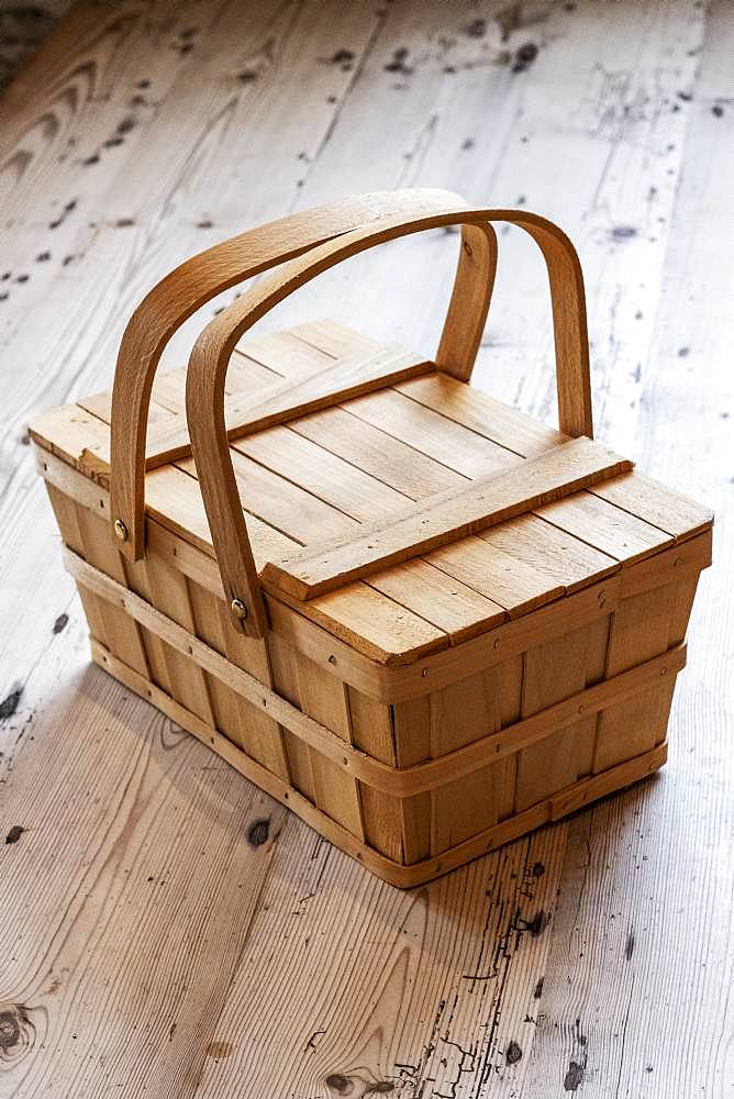 High angle close up of wooden picnic basket on wooden floor