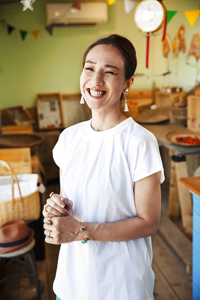 Smiling Japanese woman standing in a farm shop, looking at camera, Kyushu, Japan