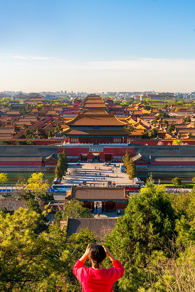 Young woman taking photograph of view over Forbidden City in Beijing, China, Beijing, China