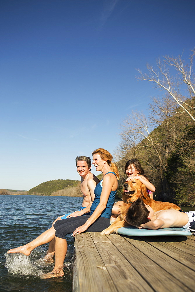 A family and their retriever dog on a jetty by a lake, Austin, Texas, USA