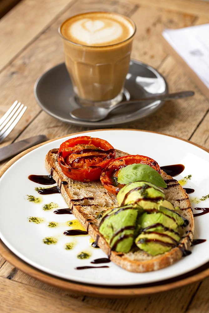 High angle close up of tomato and avocado bruschetta with balsamic vinegar reduction in a cafe