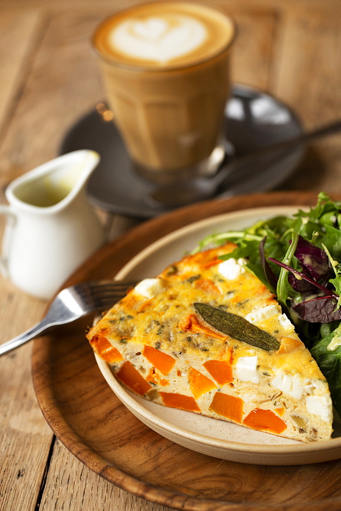 High angle close up of frittata with a with baby leaf salad in a cafe