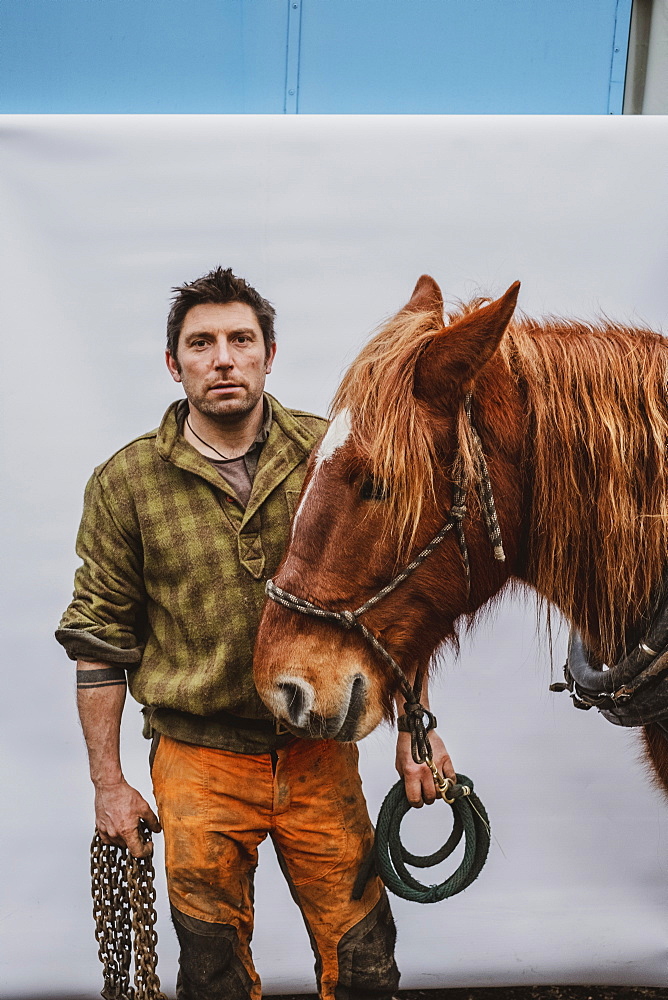 Portrait of a logger with one of his work horses, Devon, United Kingdom