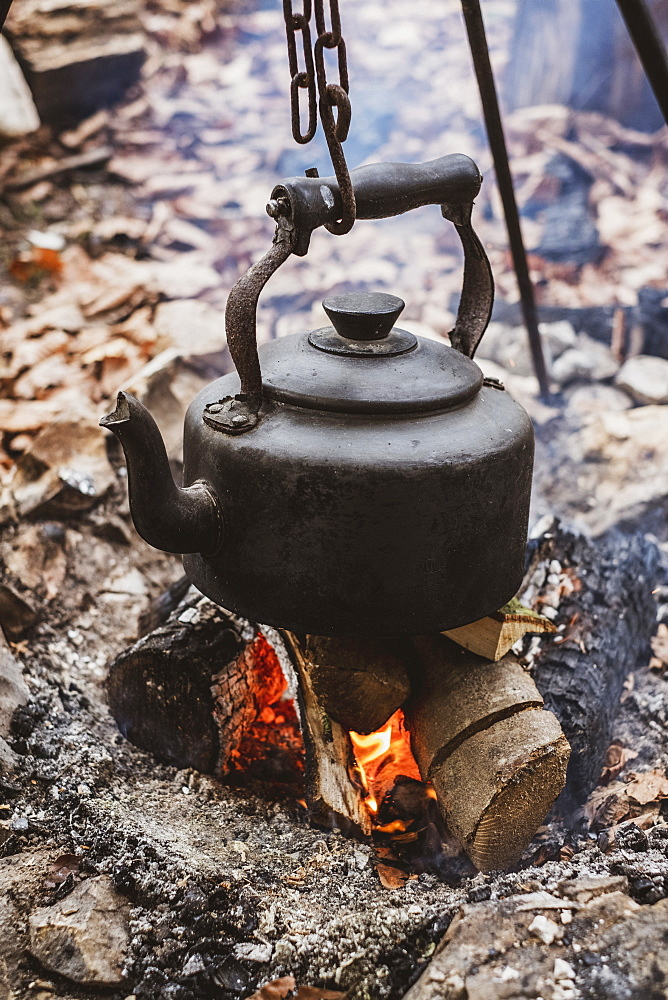 High angle close up of kettle over camp fire in a forest, Devon, United Kingdom