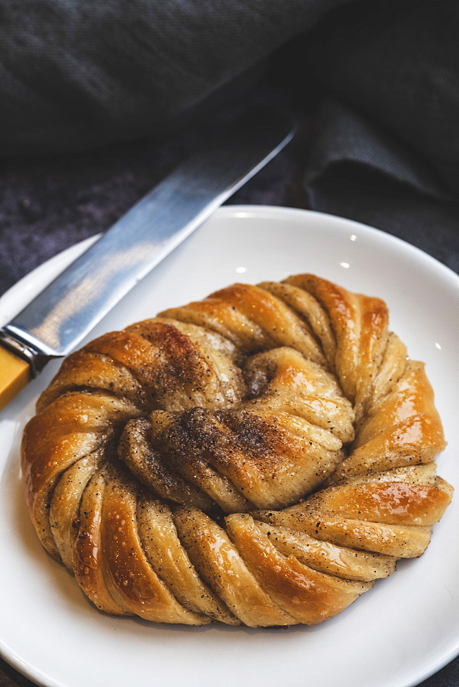 A platted glazed fresh baked cinnamon bun