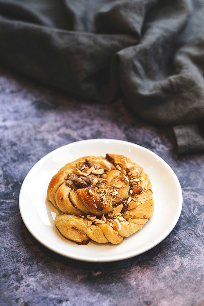 A platted glazed fresh baked cinnamon bun