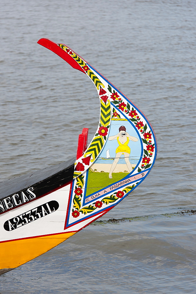 Traditional moliceiro fishing boat with a high prow, painted in vivid colours and with distinctive patterns, Ria de Aveiro Lagoon Portugal