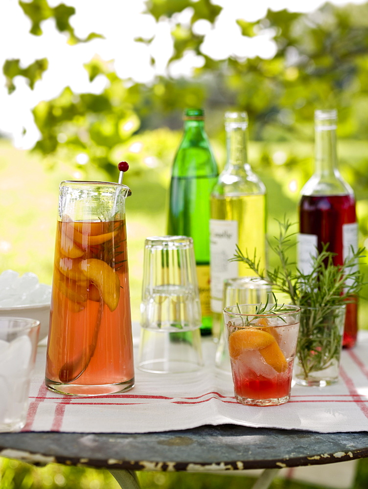 A buffet table set up in a garden for al fresco meal. Drinks, bottles, a jug of punch and glasses, Maryland, USA