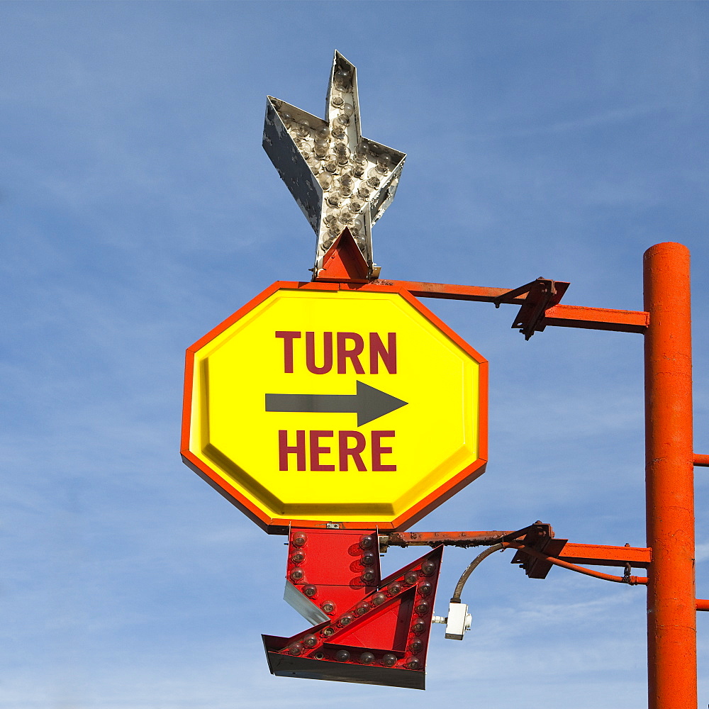 Turn Here, yellow traffic sign with arrow, on a gantry with a silver star shape, United States of America