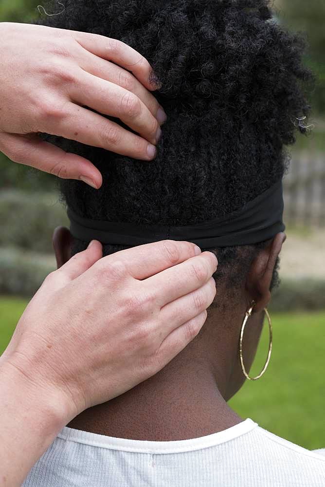 Therapist touching a client's head and neck, in an outdoor therapy session