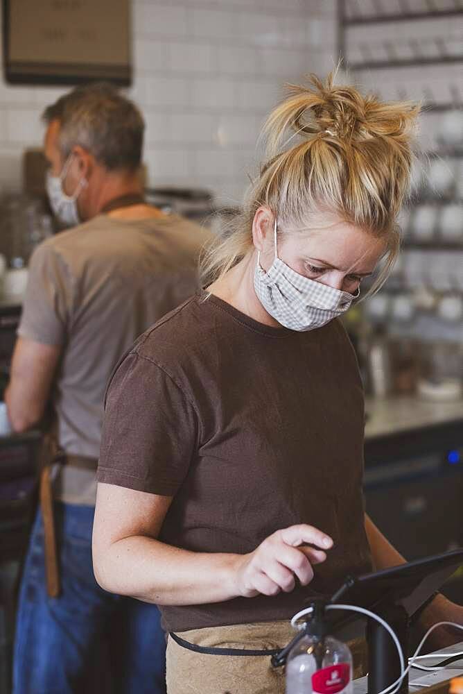 Waitress wearing face mask working in a cafe