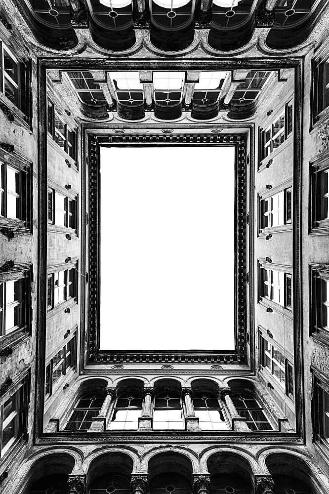 Architecture, the central courtyard of a tall historic building, windows and cornicing.