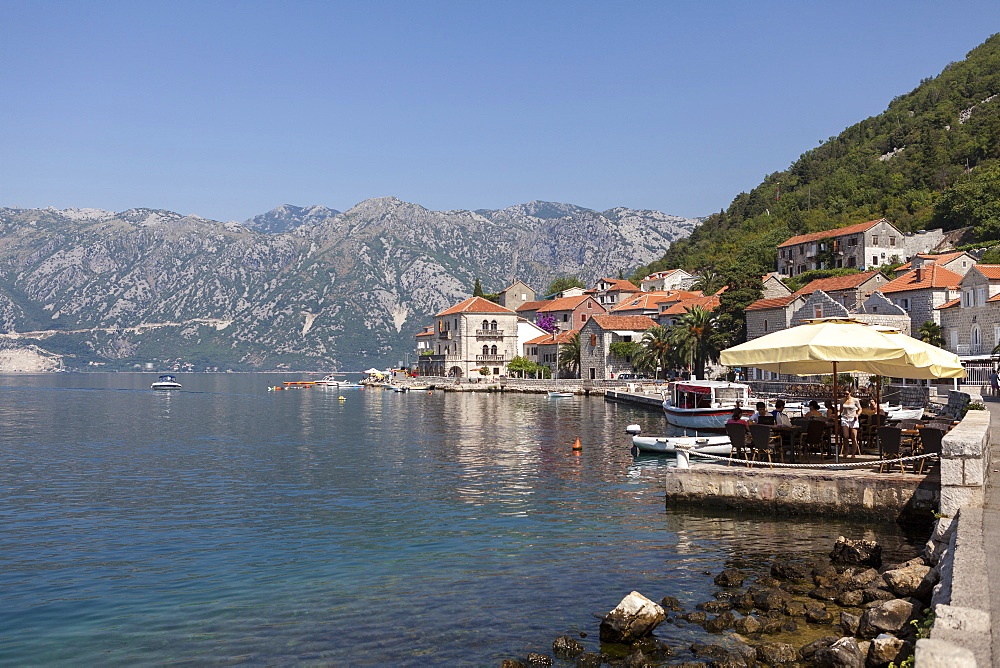 Perast harbour and promenade with tourists and inhabitants eating and drinking, Bay of Kotor, Montenegro, Europe