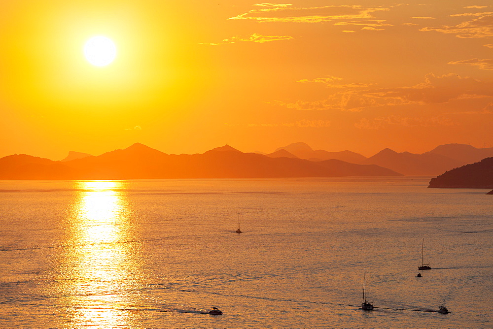 Fishing boats and speed boats return at dusk, with the island of Kolocep in the background, Dubrovnik, Croatia, Europe