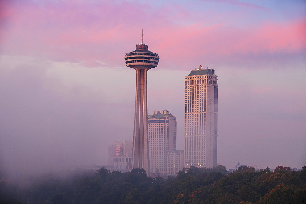 Mist from Horseshoe Falls swirling in front of Skylon Tower at dawn, Niagara Falls, Niagara, border of New York State and Ontario, Canada, North America