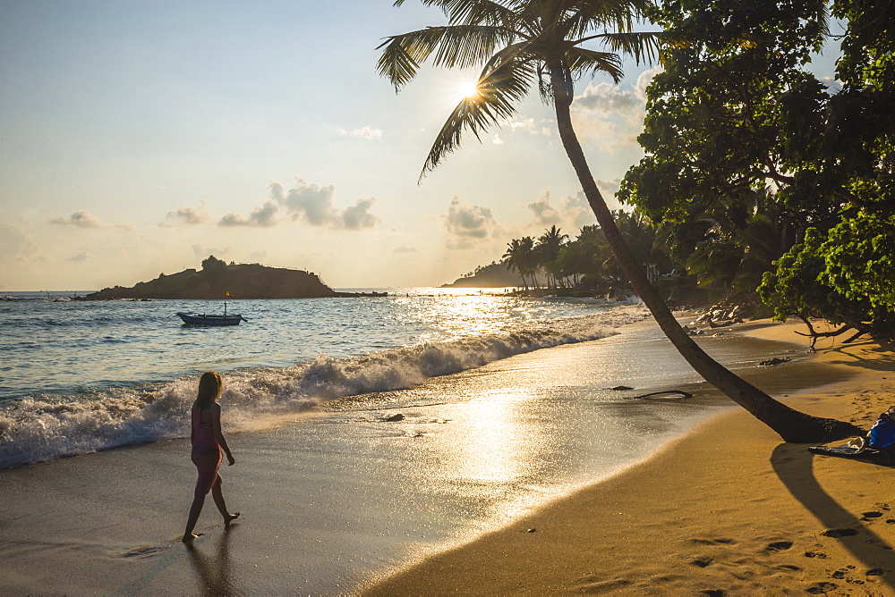 Woman walking on Mirissa Beach at sunset, Mirissa, South Coast of Sri Lanka, Southern Province, Sri Lanka, Asia