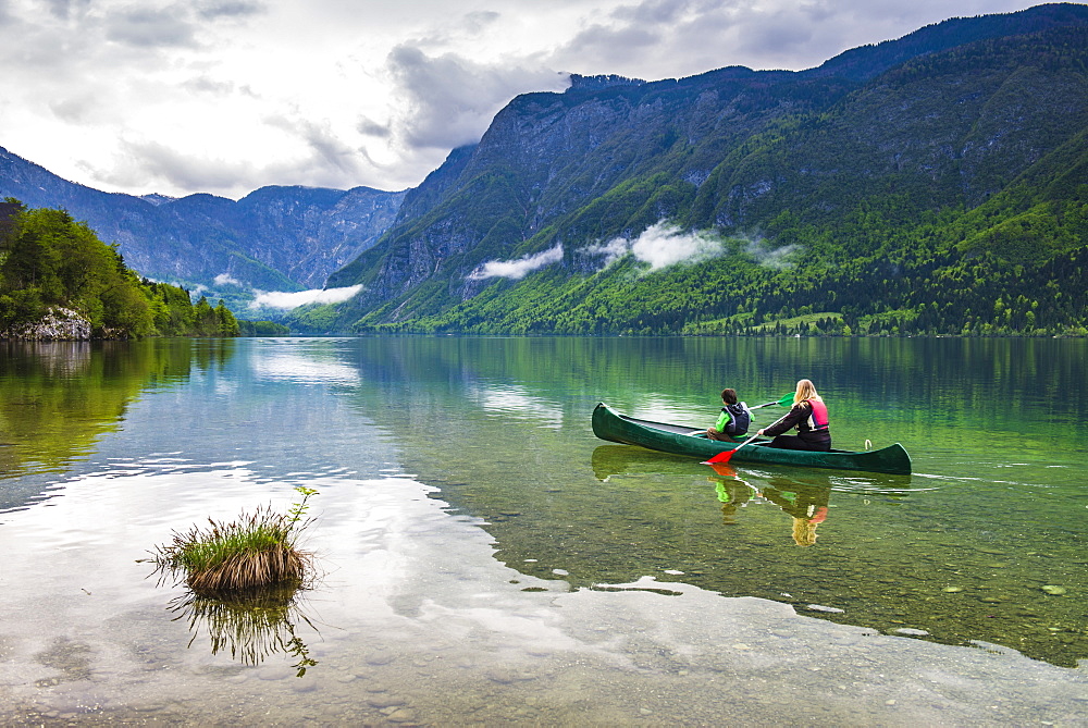 Mother and son canoeing on Lake Bohinj, Triglav National Park, Julian Alps, Slovenia, Europe