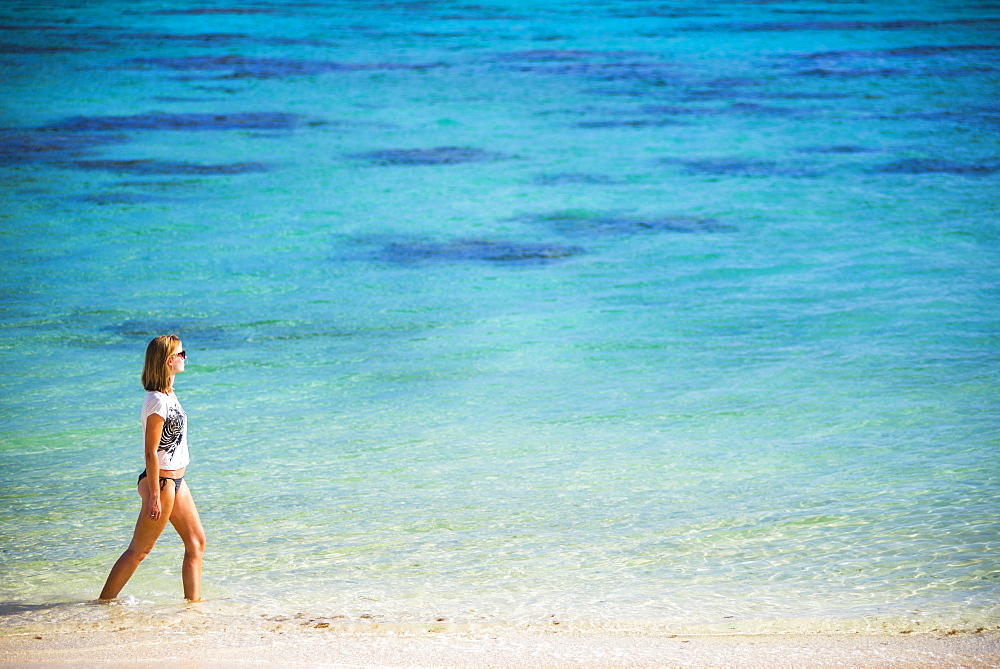 Woman walking along a tropical beach, Rarotonga Island, Cook Islands, South Pacific, Pacific