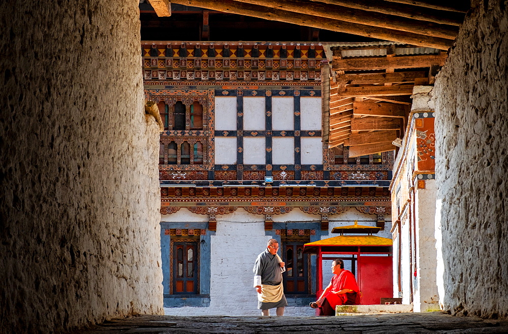 Two Buddhist monks talking inside monastery, Bhutan, Asia