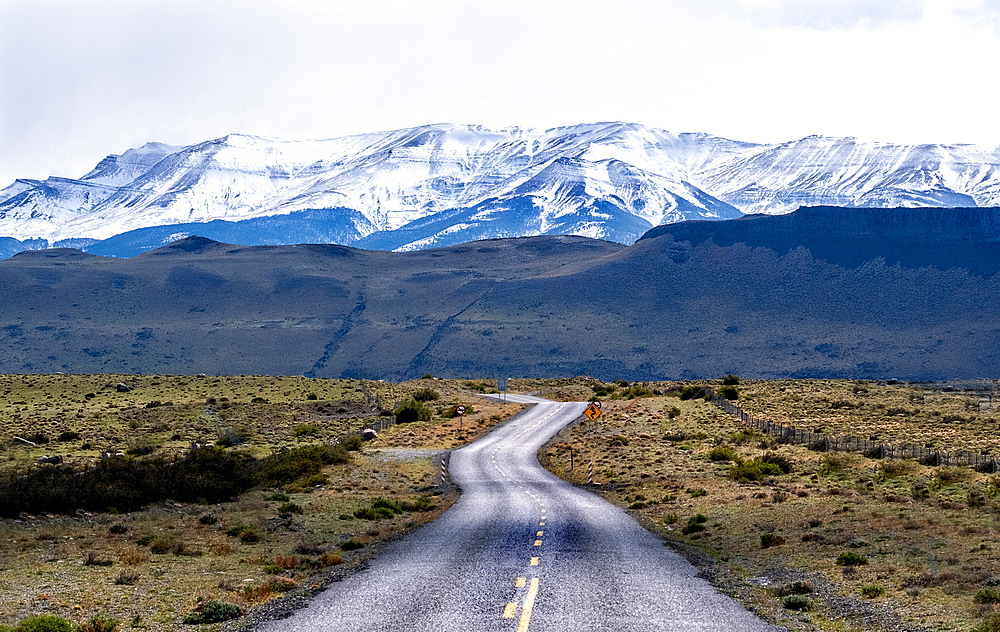 Highway leading to snow covered mountains, Torres del Paine National Park, Chile, South America