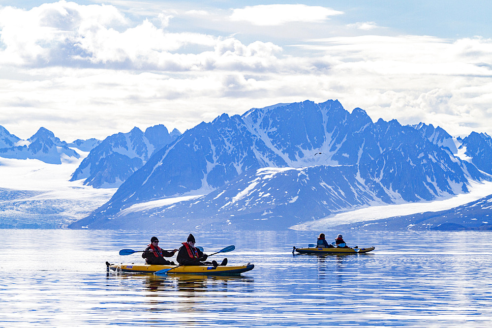 Guests from the Lindblad Expedition ship National Geographic Explorer kayaking in the Svalbard Archipelago, Norway.