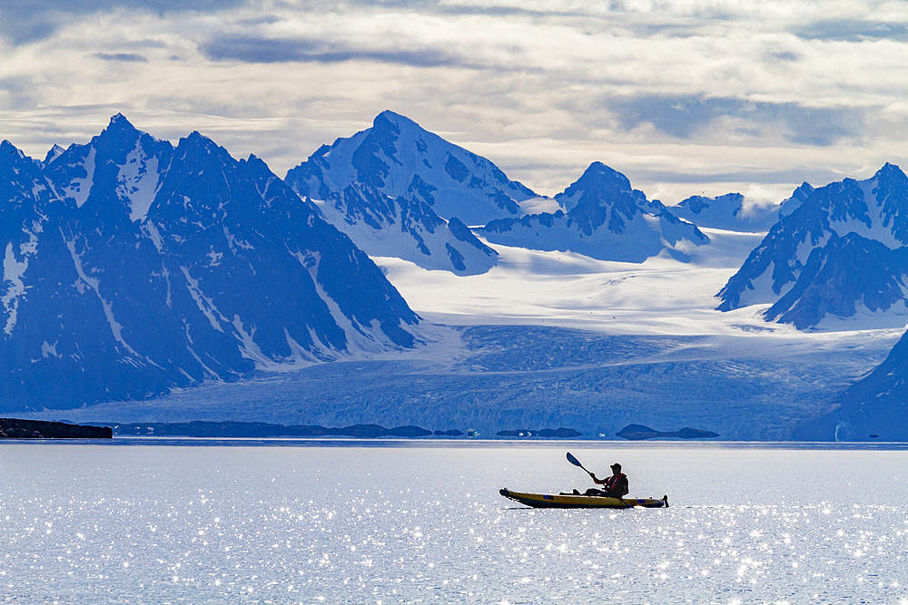 Guests from the Lindblad Expedition ship National Geographic Explorer kayaking in the Svalbard Archipelago, Norway.