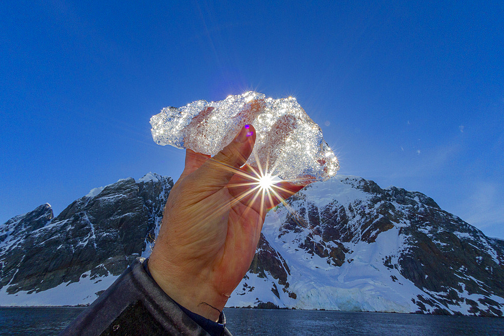 Ice held up to the sun near the Antarctic Peninsula during the summer months, Southern Ocean.