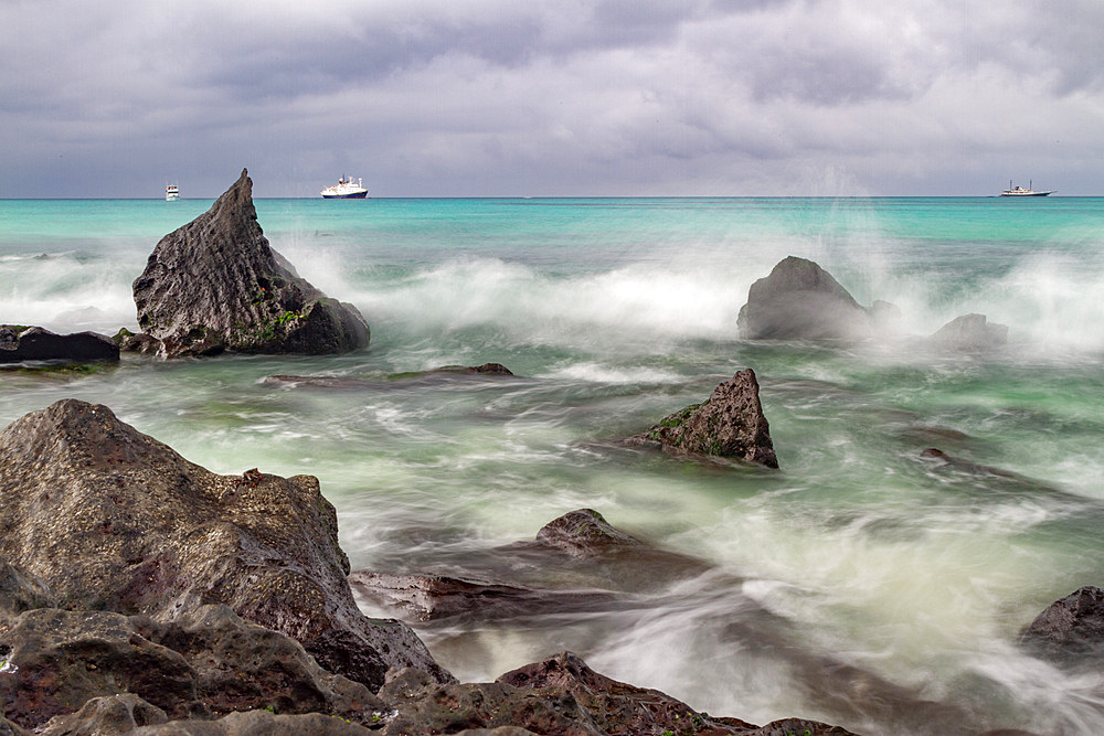 Surf breaking on lava shoreline at Gardner Bay on Espanola Island in the Galapagos Island Archipelago, Ecuador.