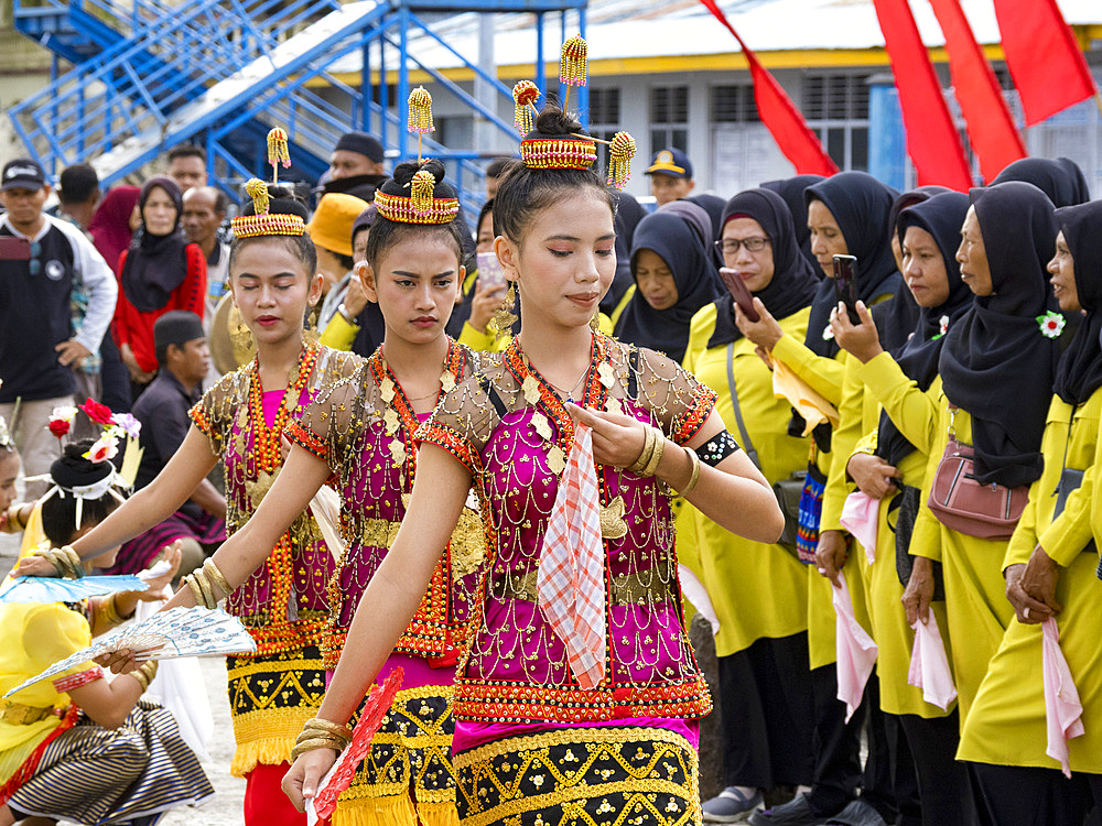 Locals in traditional costume greet our ship in the island of Banda Neira, Moluccas, Indonesia.