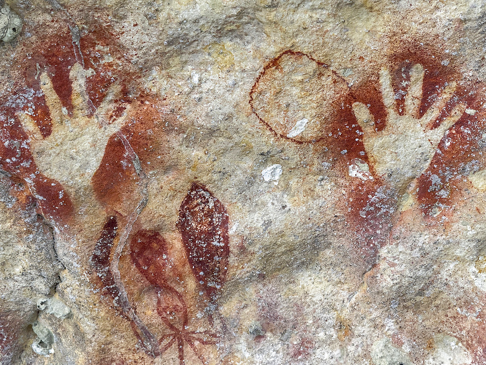 Ancient rock art painted on the limestone cliffs in Berau Bay on the island of Papua, Indonesia.