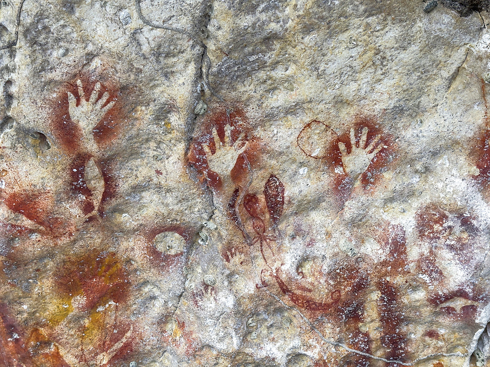 Ancient rock art painted on the limestone cliffs in Berau Bay on the island of Papua, Indonesia.